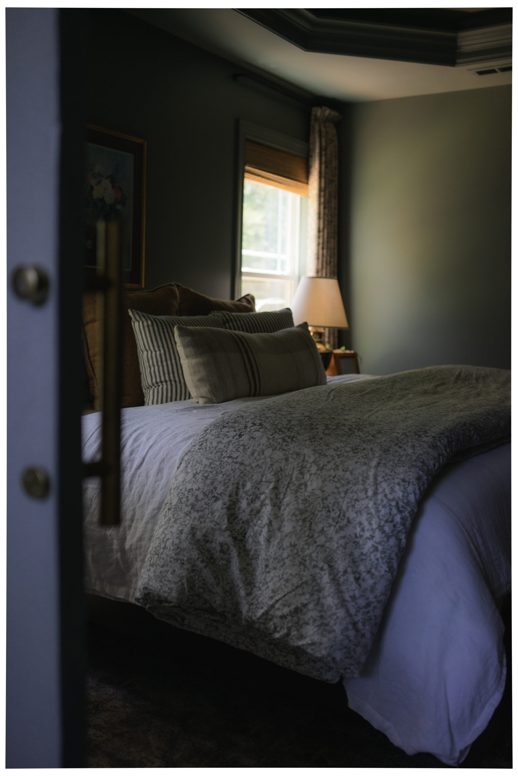Close-up of patterned bedding from the Garden Collection, styled with soft neutral pillows and rich textures in a traditional modern bedroom.